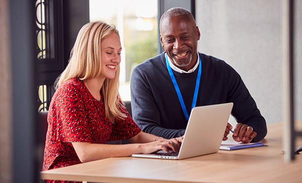 Man helping a young woman with her energy bill